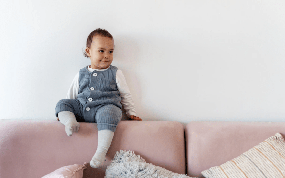 Enfant assis sur un dossier de canapé